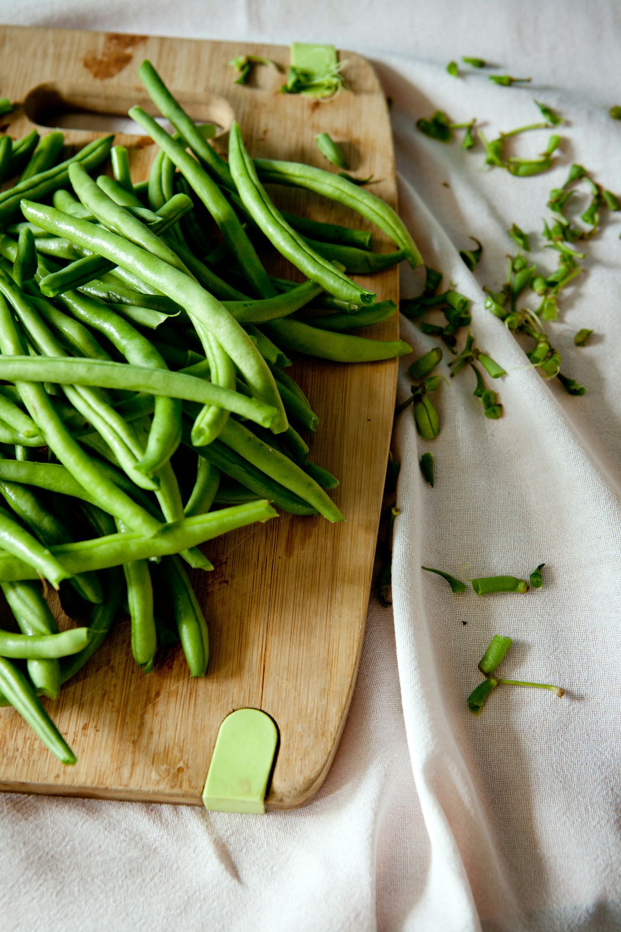 green peas on top of brown wooden chopping board